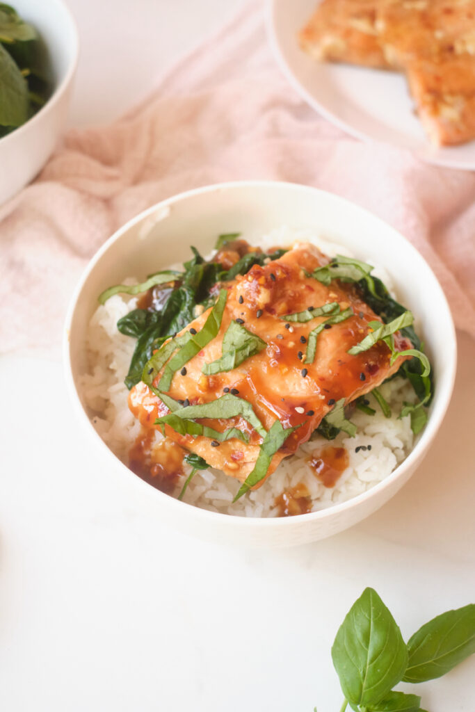 Asian rice bowl with sesame salmon, basil and spinach over rice