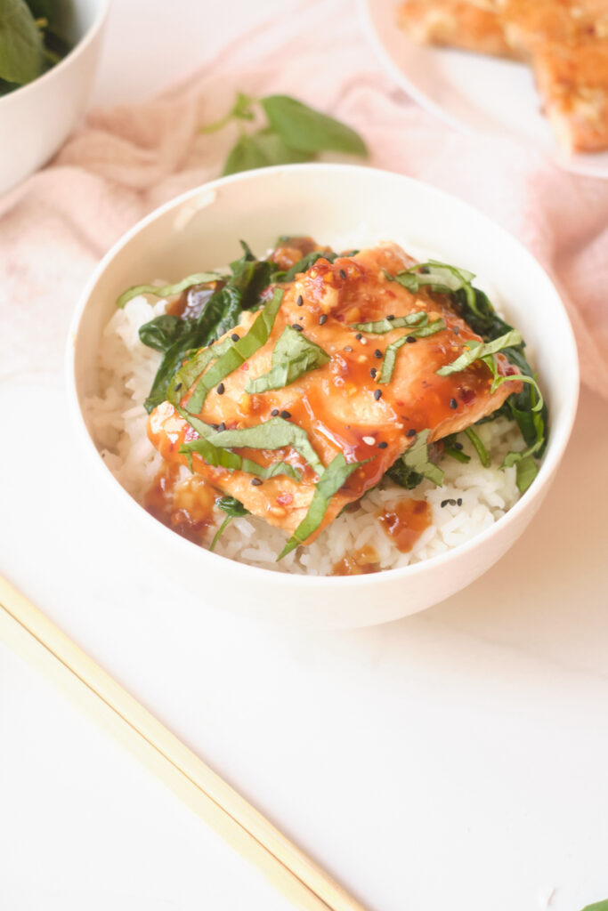 Asian rice bowl with sesame salmon, basil and spinach over rice