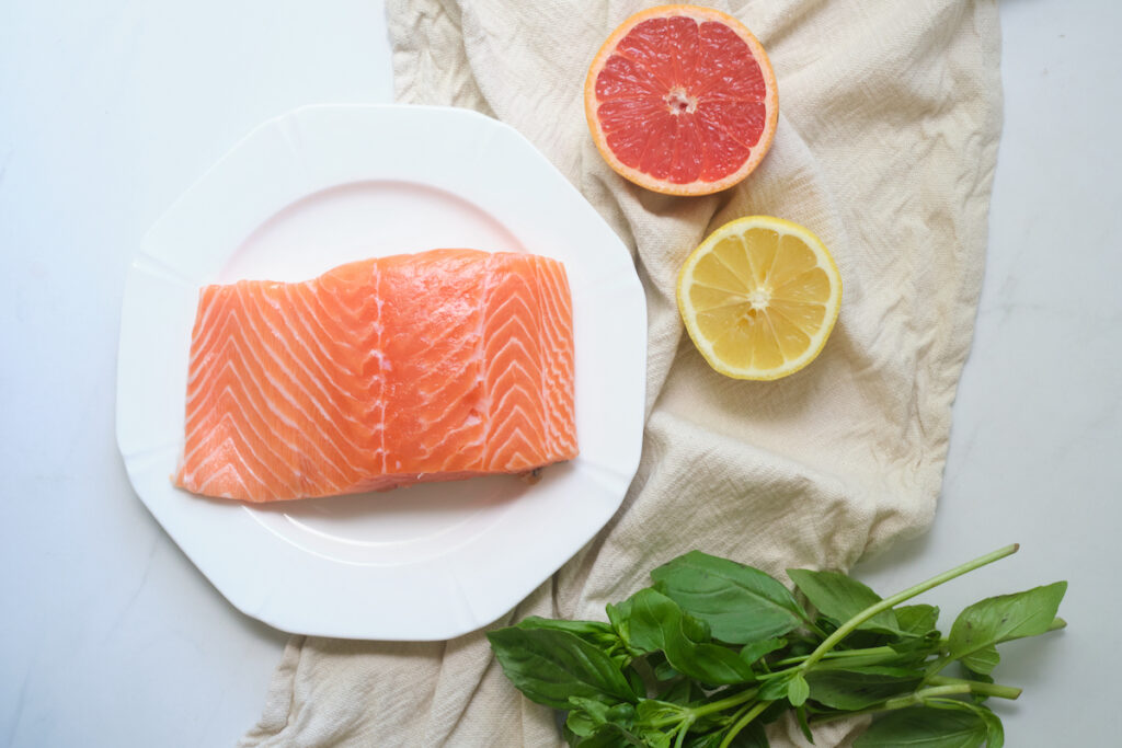 fresh salmon fillet, a bunch of basil, half a lemon, and half a grapefruit