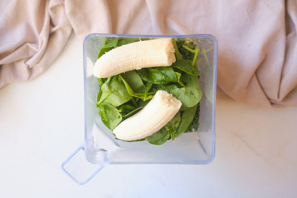 birds eye view looking down on a blender filled with banana and spinach