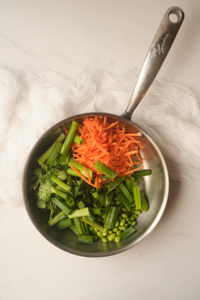 Raw veggies in a skillet ready to cook