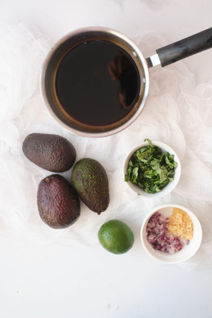 ingredients for basil guacamole with balasmic reduction on a table in advance of making