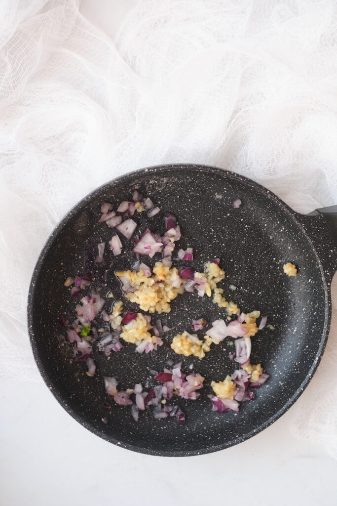 minced shallots and garlic in a frying pan