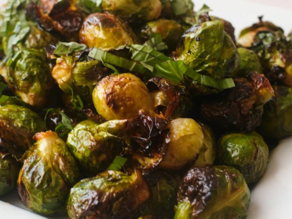 Close up of sweet and spicy roasted brussels sprouts with basil