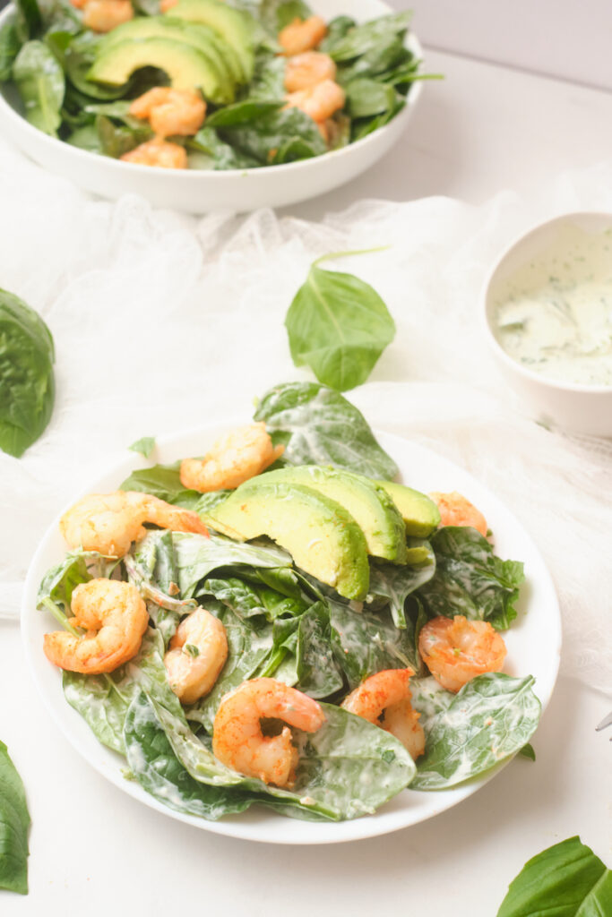 A plate of fresh chilli shrimp and avocado salad with basil green goddess dressing