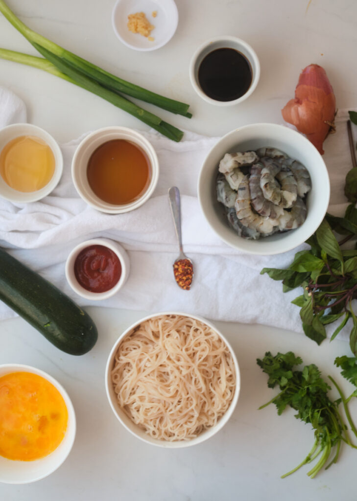 Separated ingredients for a spicy shrimp noodles with thai basil recipe