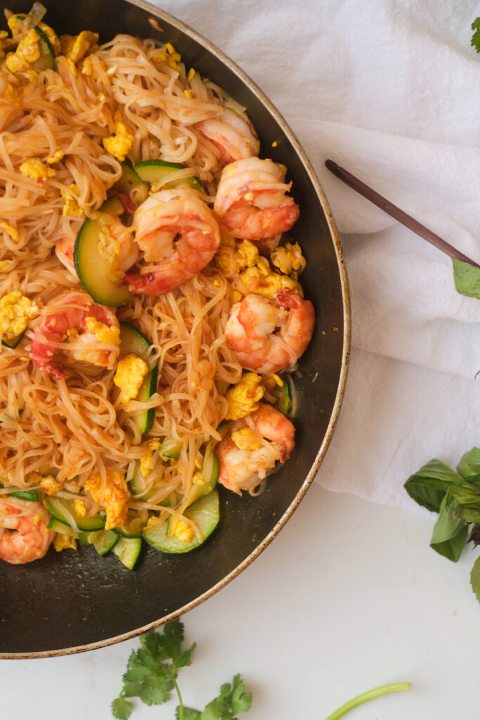 Spicy shrimp noodles with basil in a pan