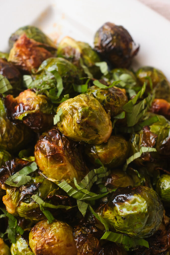 Close up of roasted sweet and spicy brussel sprouts with basil chiffonade