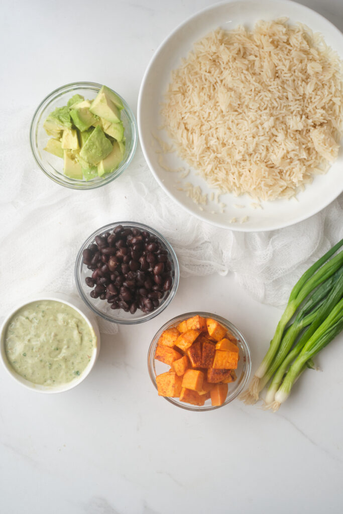 Birds eye view of ingredients for a sweet potato avocado rice bowl