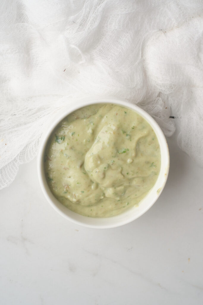 basil avocado yoghurt dressing in a white dish