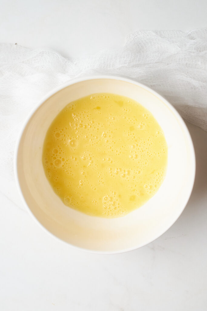 A bowl full of whisked egg mixture for an omelette