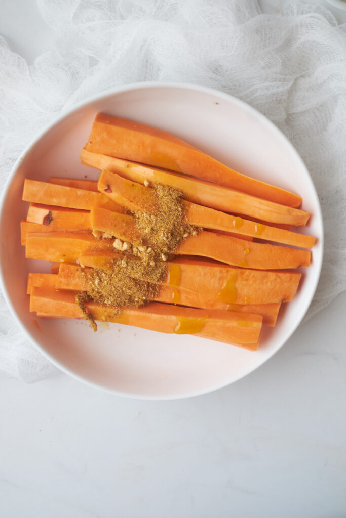 yam fries being seasoned with curry powder