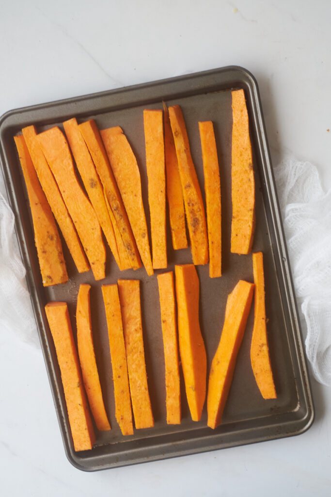 uncooked curry yam fries on a baking sheet