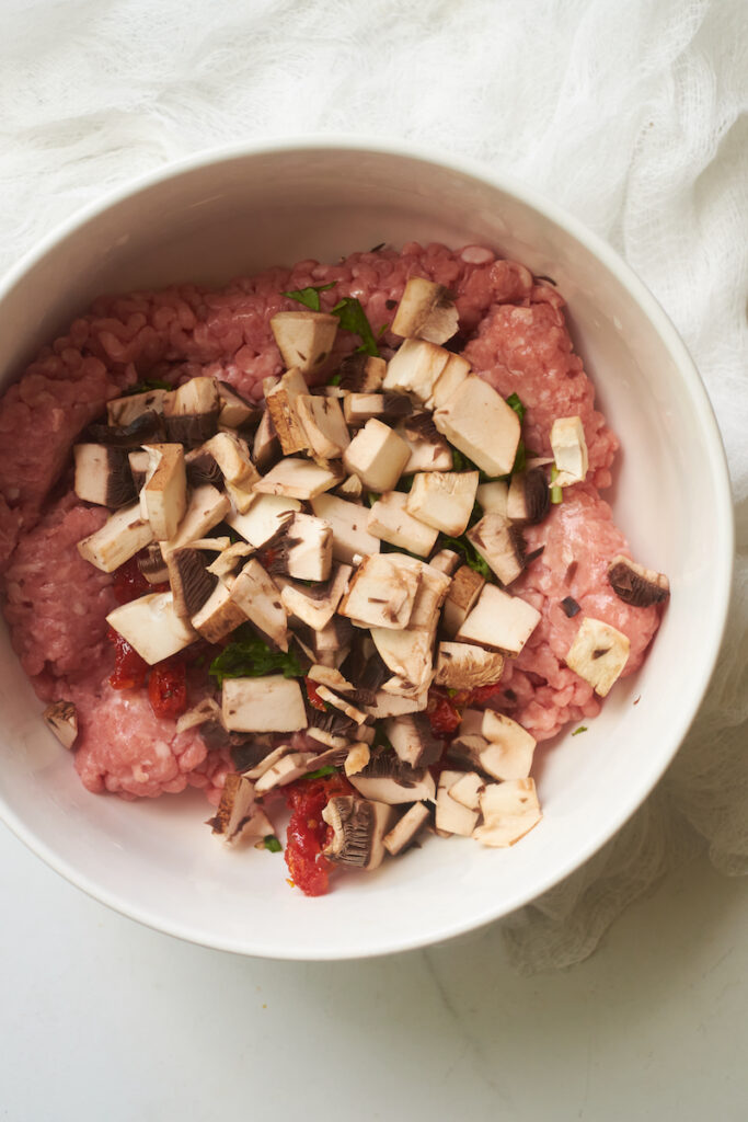 chopped portobello mushroom caps added on top of a ground turkey mixture to make portobello mushroom turkey burgers