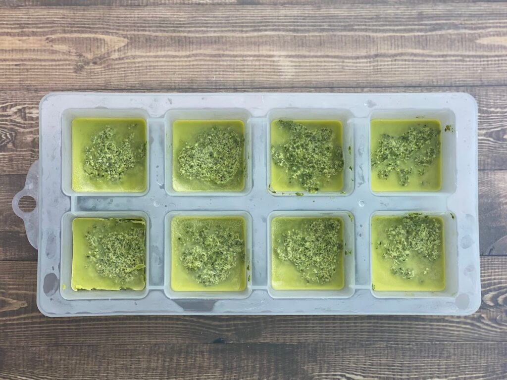 Frozen pesto cubes in an ice cube tray
