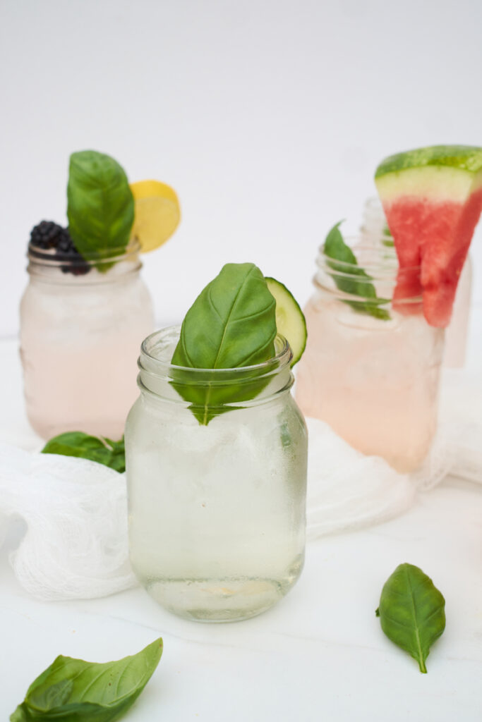 mason jars filled with basil water and other flavors including blackberry lemon basil water and watermelon basil water. You can also infuse the water with basil leaves.