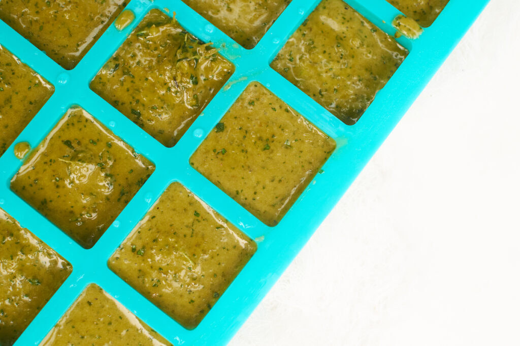 Olive oil and basil puree in a silicone ice cube tray before freezing