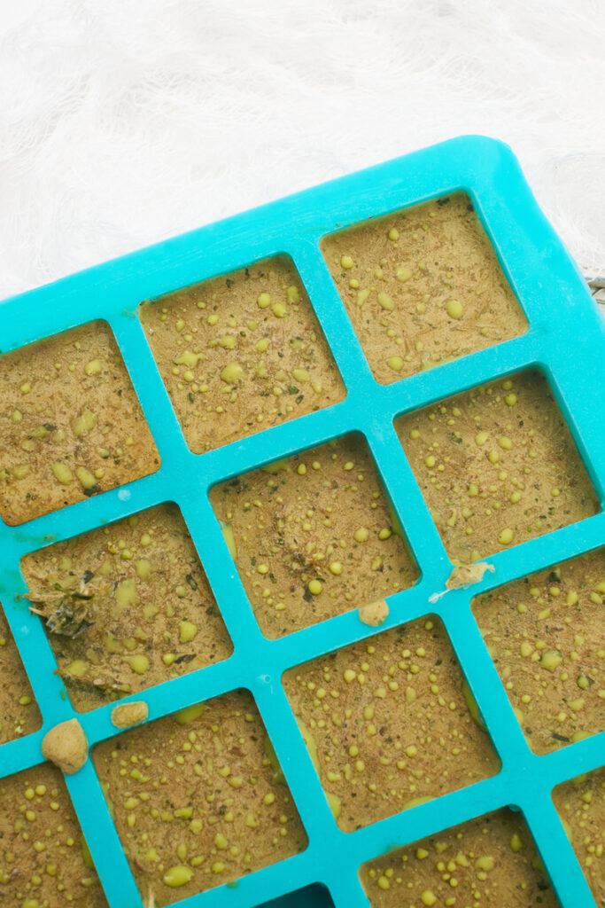 Frozen basil and olive oil cubes in a silicone ice cube tray